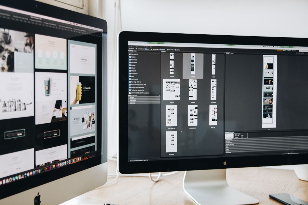 Un espace de travail moderne avec deux écrans d'ordinateur affichant des projets de conception web, mettant l'accent sur la technologie et la productivité.